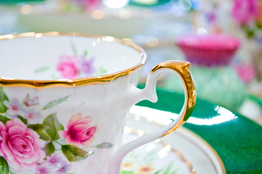 Photographie en gros plan d'une tasse en porcelaine avec dorure et motifs floraux.